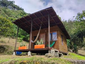 a tiny house with a roof on a hill at Refugio Munay in Florián