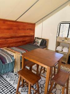 a room with a table and chairs and a bed at Peaceful Glamping Retreat at Roaring River in Cassville