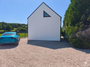 a car parked next to a large white door at Ekologiczny domek "Ciszyca" z widokiem na Śnieżkę in Kostrzyca