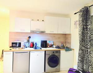 a kitchen with a washing machine and a washer at STUDIO Confort Clim 20min Orly-45min Paris Disney in Corbeil-Essonnes