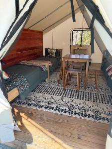 a room with two beds and a table in a tent at Peaceful Glamping Retreat at Roaring River in Cassville