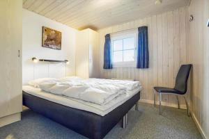 a bedroom with a bed and a black chair at BV162-Blavand-Kollemarken-31 in Blåvand +33 photos