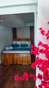 a bed in a room with red flowers at Santorini Barú in Playa Blanca