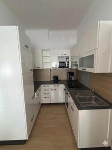 a kitchen with white cabinets and a sink at Stratos Apartments in Laa an der Thaya
