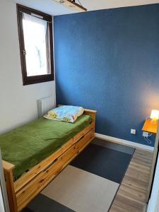 a small room with a bed with a window at EcrAin Montagnard in Lélex