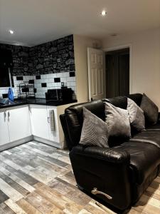 a black leather couch sitting in a living room at Blackamores chalet in Mablethorpe +4 photos