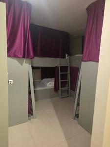 a room with two bunk beds and purple curtains at Muscat Beach Hostel in Muscat +6 photos