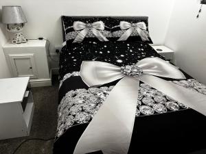 a black and white bed with bows on it at Blackamores chalet in Mablethorpe