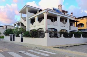 a white building on the side of a street at Appartamenti Il Glicine Villasimius in Villasimius