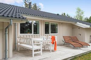 a patio with a table and chairs on a deck at BV235-Oksbol-Kaervej-2 in Oksbøl