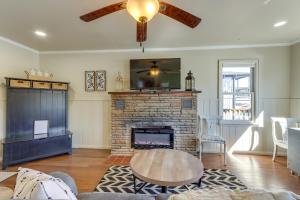 a living room with a fireplace and a ceiling fan at Lakefront Eucha Escape w/ Views & Boat Slip! in Eucha +16 photos