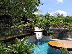 a pool with a water slide in a resort at Villa BotaNICA guest house in San Juan del Sur