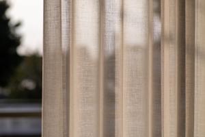 a beige curtain in a window at Casa Angelica in Patitiri