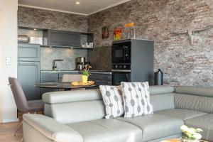 a living room with a couch and a kitchen at Encore Seaside in Büsum