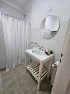 a white bathroom with a sink and a mirror at Casita Cómoda y Acogedora in Trenque Lauquen +15 photos
