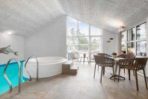 a bathroom with a tub and a table and chairs at BV267-Blavand-Karl-Postsvej-5 in Blåvand