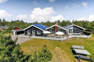 a house with a blue roof on top of a field at BV267-Blavand-Karl-Postsvej-5 in Blåvand