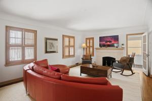 a living room with a red couch and a fireplace at Como Classic in Saint Paul