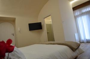 a bedroom with a bed and a television on the wall at Il Cortile del Principe in Castel di Sangro