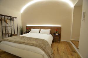 a bedroom with a large white bed and wooden floors at Il Cortile del Principe in Castel di Sangro