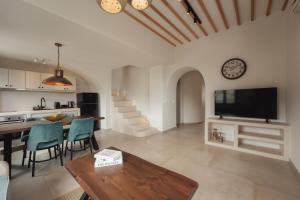 a kitchen and living room with a table and a tv at Galaria Serenity Suites in Vóthon