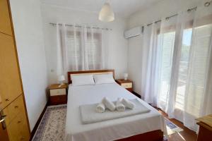 a bedroom with a bed with two towels on it at Villa Erato Keratea in Keratea +35 photos
