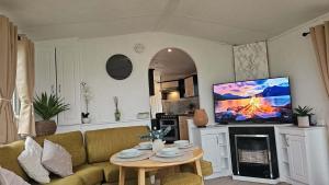 a living room with a couch and a tv at 16 farmfield in Skipsea