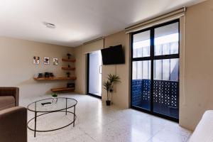 a living room with a table and a large window at Cardedeu Express Hotel in San Salvador