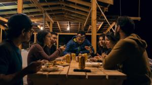a group of people sitting around a table eating food at Refugio Munay in Florián