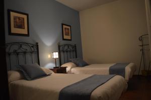 a hotel room with two beds and a lamp at CASA RURAL LA IBIENZA in Zarzuela del Pinar +2 photos