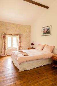 a bedroom with a large bed and a window at Le Pistoulet Gîte in Doeuil-sur-le-Mignon