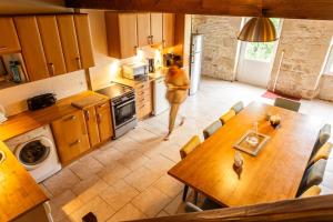 a woman in a kitchen with a table in a kitchen at Le Pistoulet Gîte in Doeuil-sur-le-Mignon