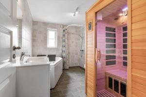 a bathroom with a tub and a sink and a shower at BV374-Blavand-Krogsande-22 in Blåvand +52 photos