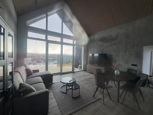 a living room with a couch and a table at Aurora luxury villa in Reykholt +44 photos