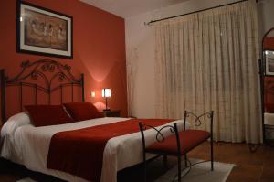 a bedroom with a large bed with red walls at CASA RURAL LA IBIENZA in Zarzuela del Pinar