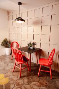 a table and two red chairs in a room at Cardedeu Express Hotel in San Salvador