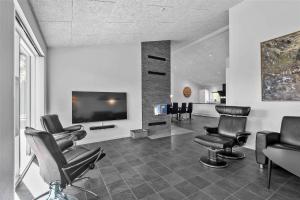 a salon with black chairs and a flat screen tv at BV144-Blavand-Horntoftvej-13 in Blåvand