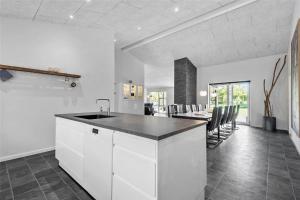 a kitchen with white cabinets and a table with chairs at BV144-Blavand-Horntoftvej-13 in Blåvand