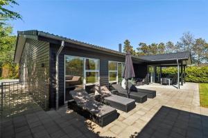 a patio with couches and an umbrella at BV144-Blavand-Horntoftvej-13 in Blåvand