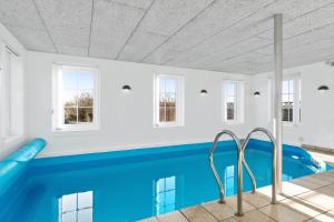 a swimming pool in a house with a blue swimming pool at BV277-Blavand-Klitvej-4 in Blåvand