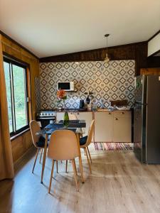 a kitchen with a table and chairs in a room at Cabañas Los Glaciares in Coñaripe