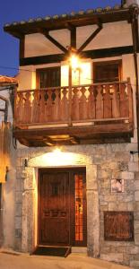 un bâtiment avec un balcon au-dessus dans l'établissement Posada La Gatera, à Pedro Bernardo