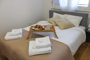 a bed with a tray with a plate of food on it at Square Garden apartment in Novi Sad