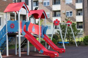 a playground with a slide in front of a building at Square Garden apartment in Novi Sad