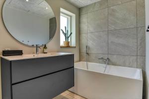 a bathroom with a tub and a sink and a mirror at BV234-Blavand-Pouls-Bjerge-14 in Blåvand +71 photos