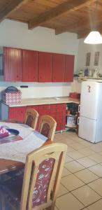 a kitchen with a table and chairs and a white refrigerator at LeśnyZakątekNysa in Skorochow +11 photos