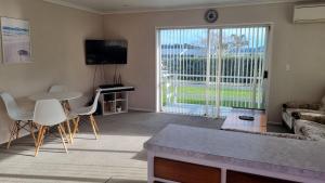 a living room with a couch and a table at Hooked On Tiki in Coromandel Town