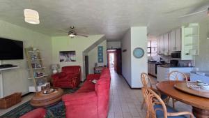 a living room with a red couch and a table at Beach Bliss Retreat in Margate