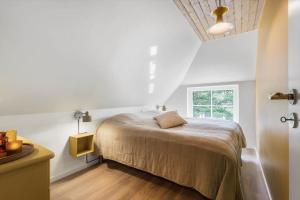 a bedroom with a bed and a window at BV264-Blavand-Solhaven-47 in Blåvand
