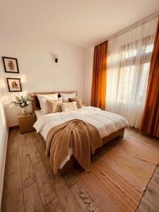 a bedroom with a large bed and a window at Serenity Apartments and Studios in Eforie Nord